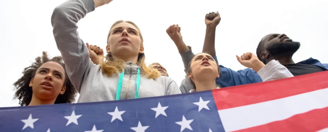 people standing behind American flag